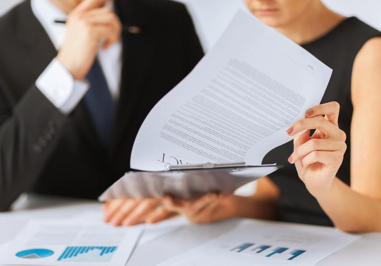 Senior banking regulatory consultants reviewing compliance documentation